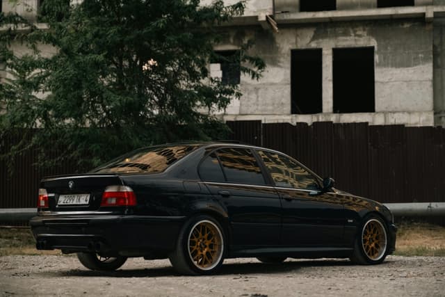 A sleek black car parked near a construction site in Grozny, Chechen Republic, Russia.