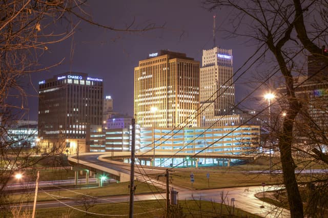 Cityscape featuring illuminated office buildings at night, showcasing modern urban architecture.
