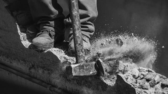 Close-up of worker using a sledgehammer to demolish concrete in Buenos Aires.