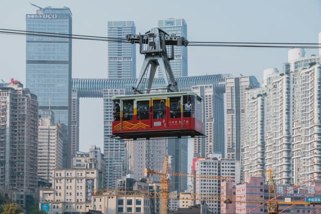 Chongqing's iconic cable car traversing the skyline, showcasing urban architecture.