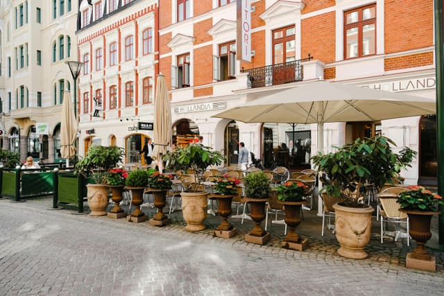 Charming cafe terrace in Malmö, Sweden, with colorful facades and outdoor seating.