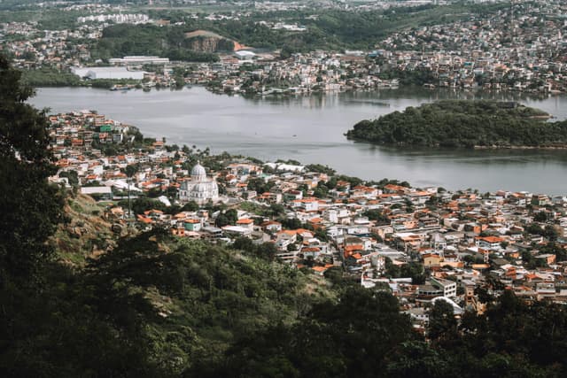 A breathtaking aerial shot of a city with a prominent dome building by a river, surrounded by lush greenery.