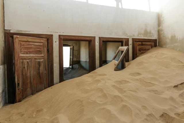 Interior of an abandoned house filled with sand dunes in Kolmanskop, Namibia.