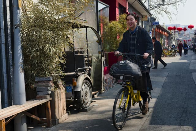 Cyclist rides along a vibrant street in a historical neighborhood with traditional architecture in springtime