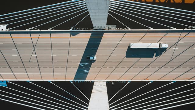 Aerial shot of a modern suspension bridge in Louisville with vehicles in motion.