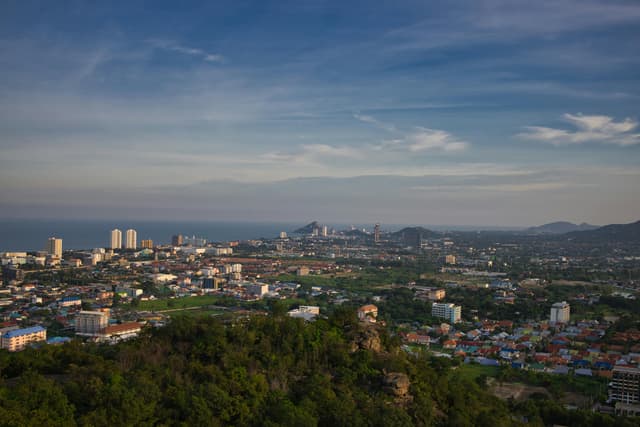 Panoramic aerial view of Hua Hin, Thailand with cityscape and ocean in the distance.