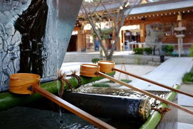 Explore a serene water basin at a traditional Japanese shrine in Fukuoka.