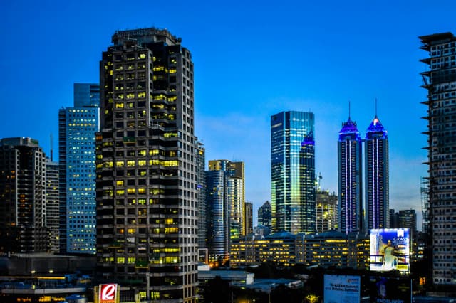 Illuminated skyscrapers at night in Pasig City, Philippines, showcasing modern architecture.