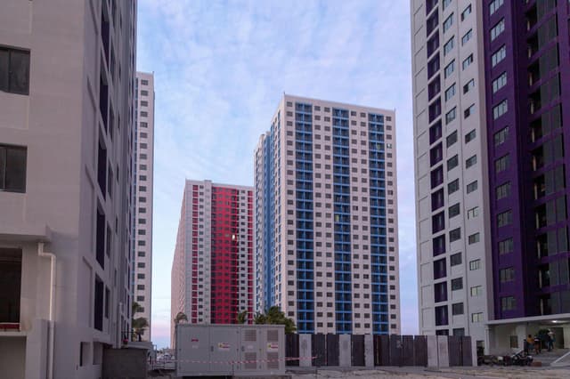 View of modern skyscraper apartment buildings during twilight with a serene sky.